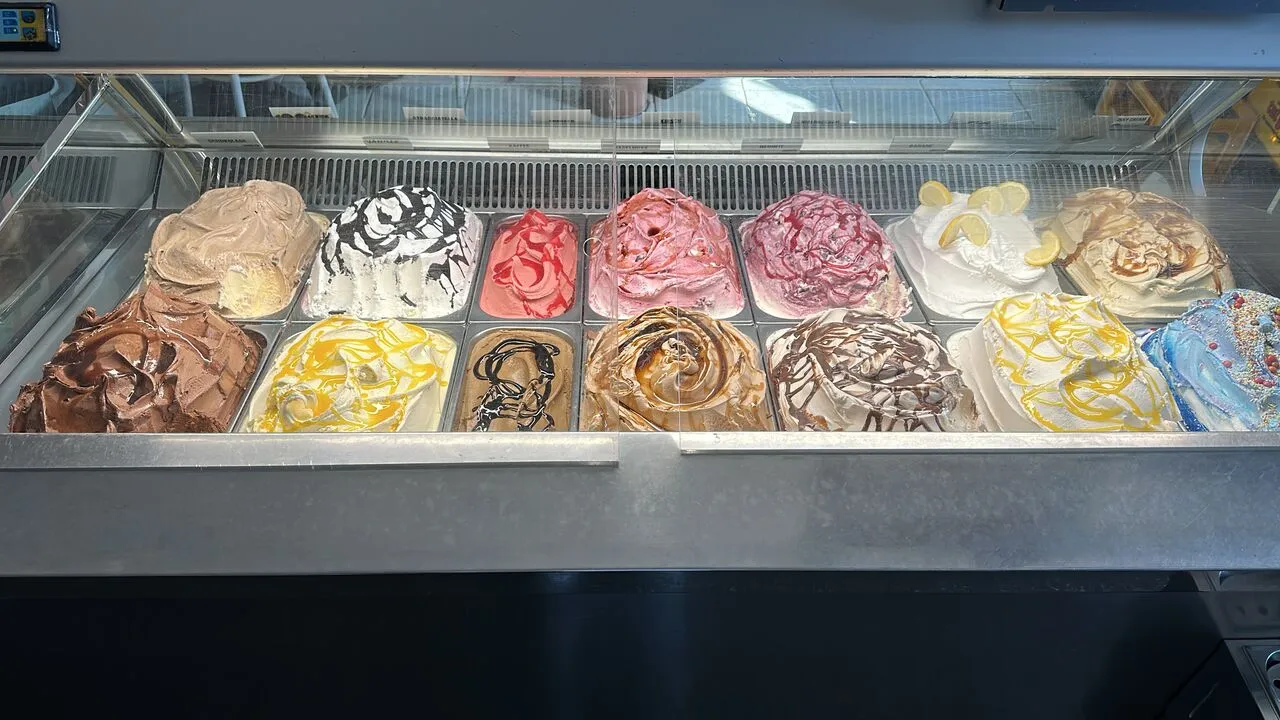 Die Eisvitrine mit sechzehn Sorten, darunter Schokolade, Erdbeere, Zitrone und Karamell